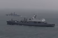 Een marineschip escorteert een ander schip op zee.