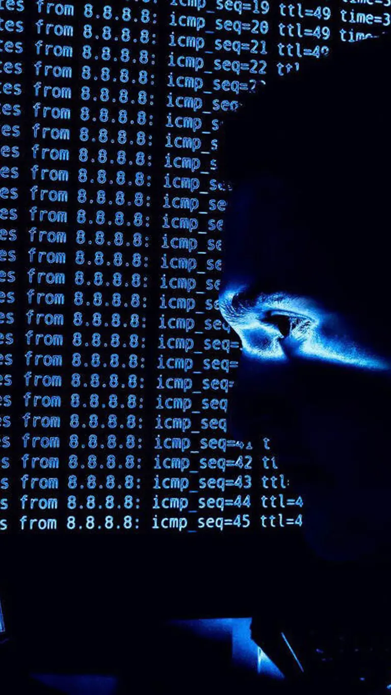 ICT’er in het donker achter computerscherm.