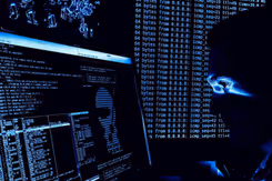 Een man kijkt in het donker naar een computerscherm.