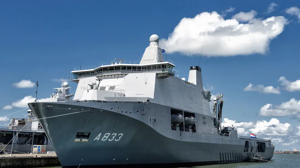 Wit schip met grijze onderkant ligt aan de haven.