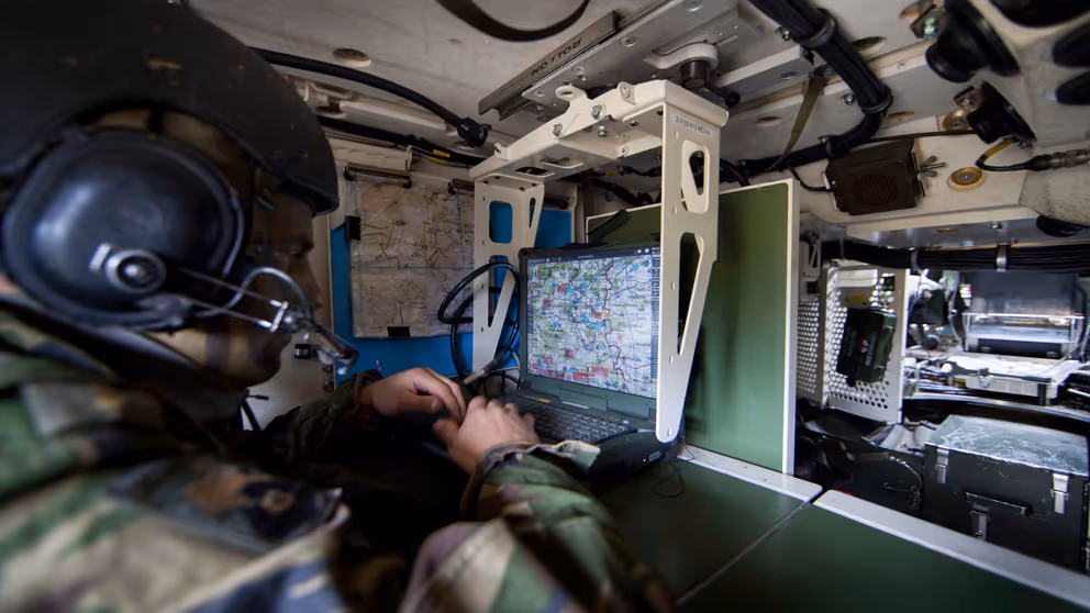 Een militair aan het werk met communicatie-apparatuur.