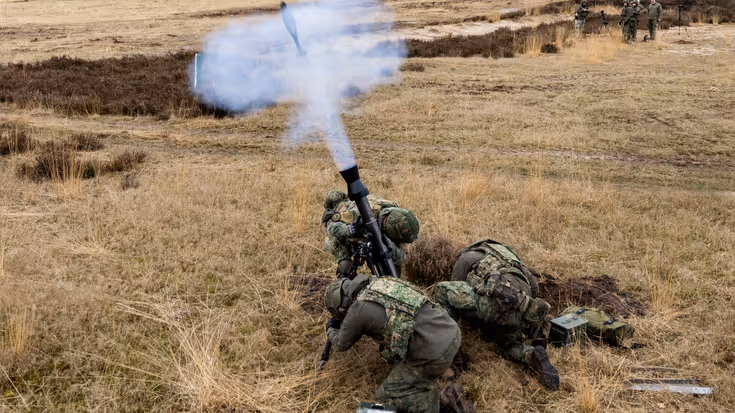 Militairen vuren al liggend op de buik mortieren af.