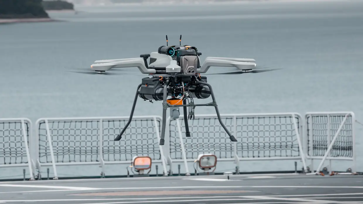 Een drone hangt boven een helidek.