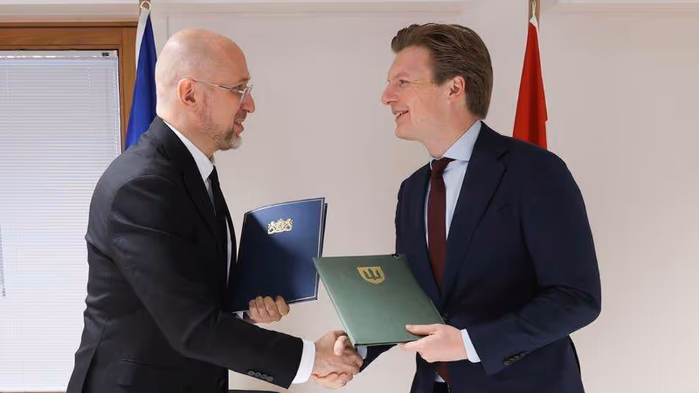 De defensieministers van Oekraine en Nederland schudden elkaar de hand.