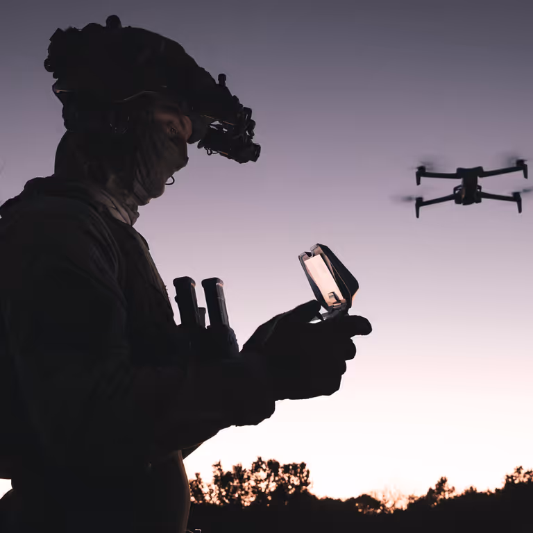 Militair bestuurt drone bij zonsondergang
