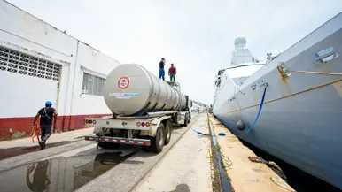 Zr.Ms. Groningen ligt aan de kade, links staat een tankwagen.
