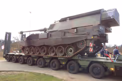 Een oplegger met daarop een pantserhouwitser geladen.