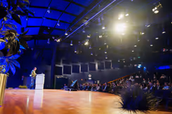 Een man voor een spreekgestoelte voor een gevulde zaal