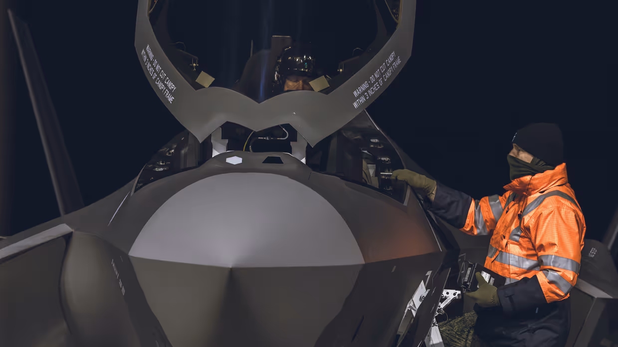 Grondpersoneel praat bij open F-35 met vlieger.