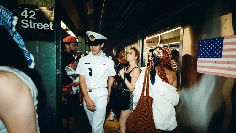 Een marineofficier en een dame die wat afstandelijk naar de grond kijkt.  