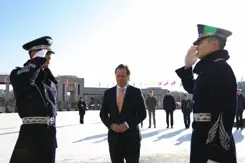 Staatssecretaris Tuinman staat tussen 2 saluerende Zuid-Koreaanse militairen. 