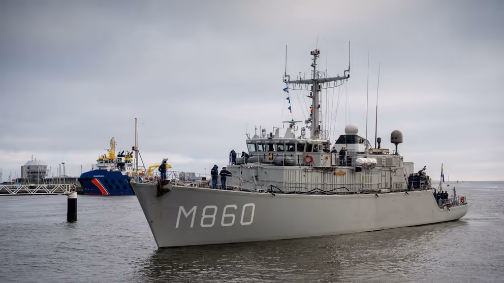 Mijnenjager M860 vaart een haven binnen.