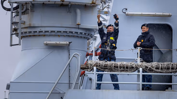 Een militair steek uitbundig zijn armen in de lucht.