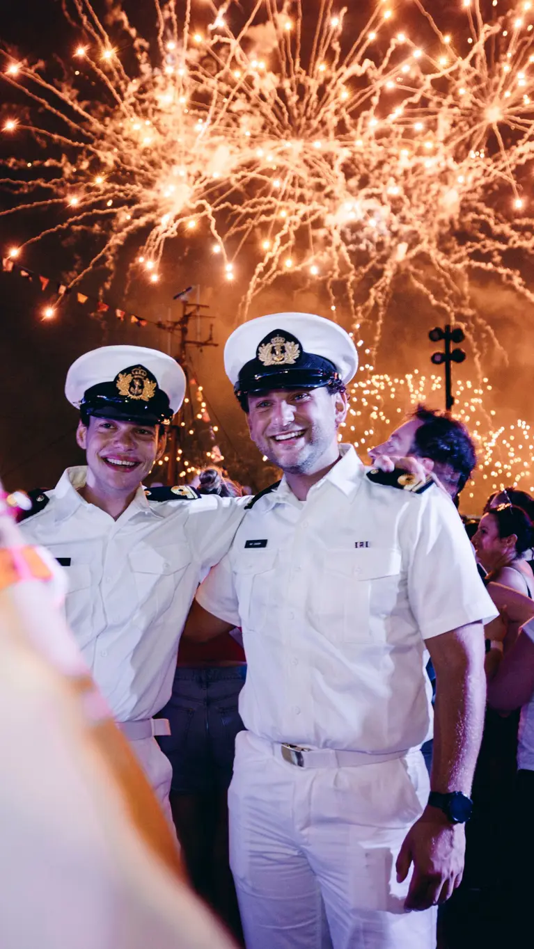 Oplichtend vuurwerk met daarvoor een aantal marinemannen.