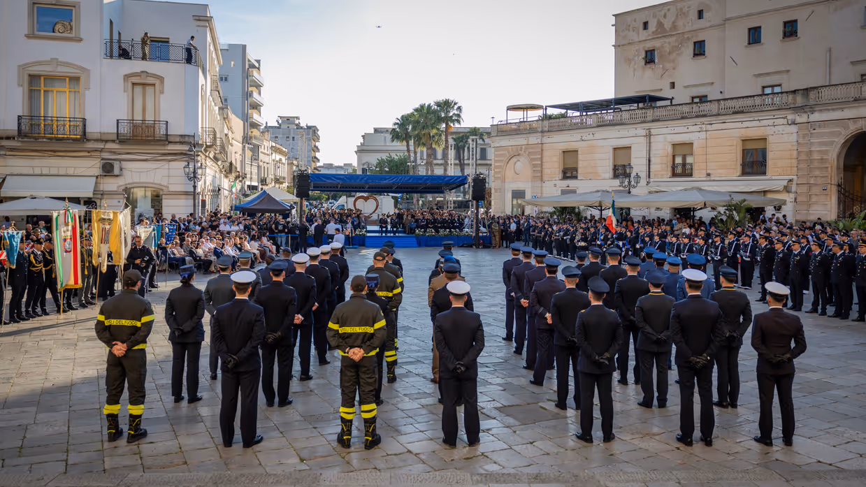 Italiaans plein met diverse groepen opgestelde militairen. Er omheen staat en zit publiek.