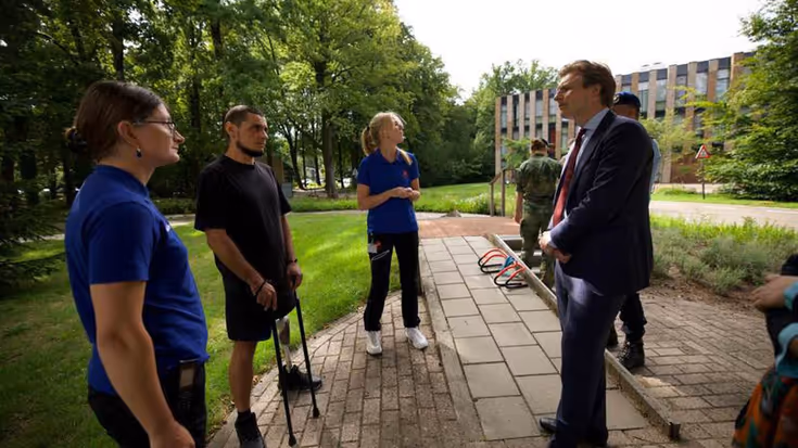 De minister in gesprek met revaliderende militairen.