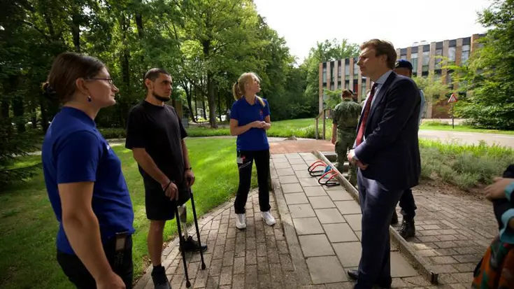 De minister in gesprek met revaliderende militairen.