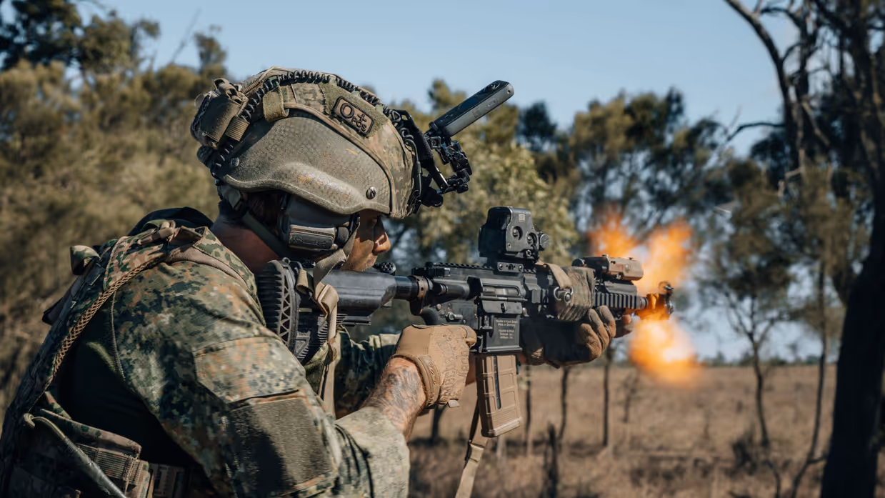Een militair vuurt een automatisch vuurwapen.