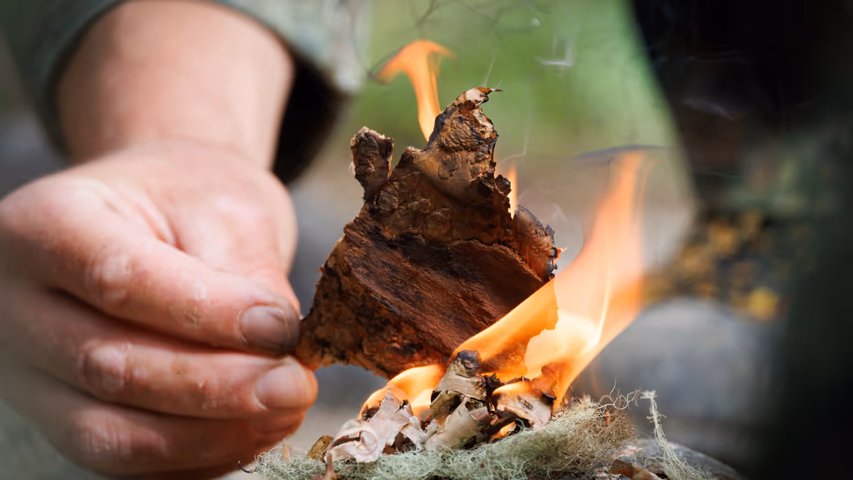 Closeup van de handen van een militair die een vuurtje start.