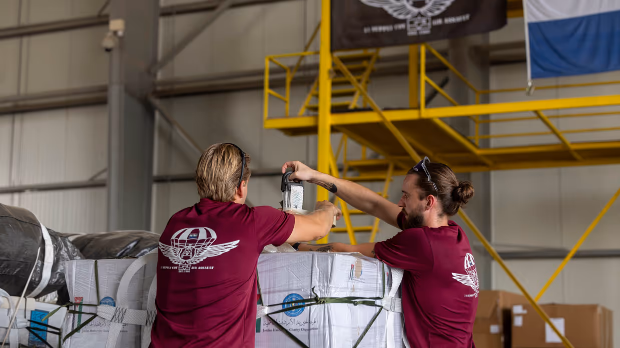 Magazijnmedewerkers pakken een pallet met goederen in.