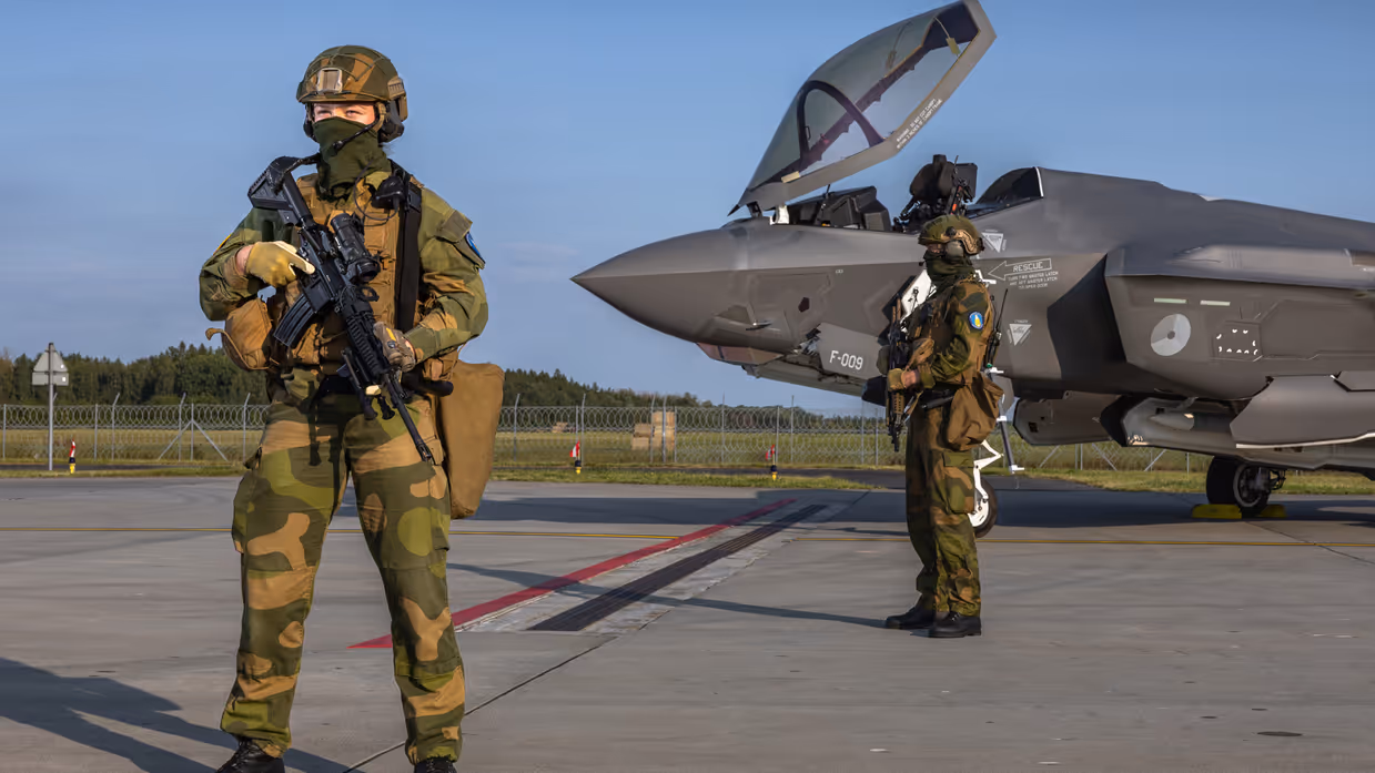 Twee militairen staan op wacht bij een F-35 straaljager.