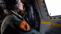 Militair met Orange Shield patch kijkt naar buiten.