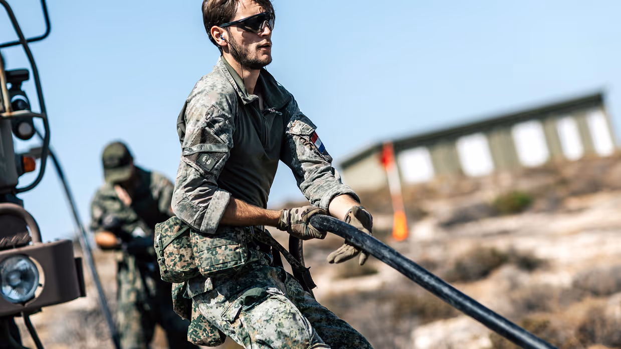 Een militair is een kabel aan het verplaatsen.