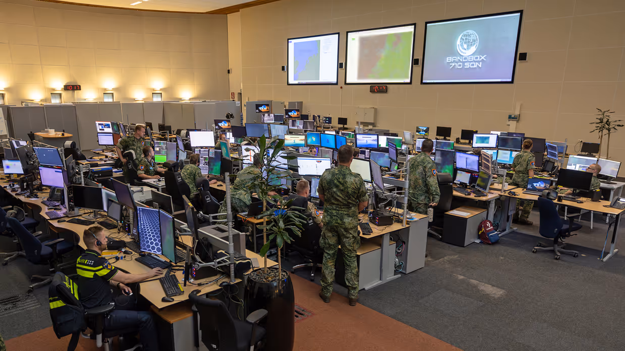 Mission control kamer gevuld met computers en staff.