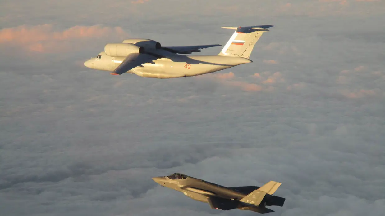 Een Nederlands toestel dat een Russisch vliegtuig in de lucht begeleidt.