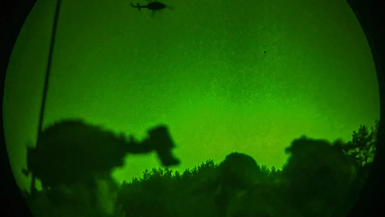 Foto’s van de Live Fire-oefening door een nachtkijker genomen waarbij vanuit een helikopter wordt geschoten.