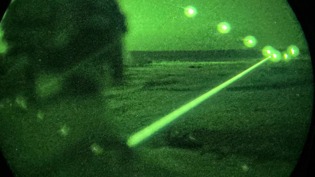 Foto’s van de Live Fire-oefening door een nachtkijker genomen waarbij vanuit een helikopter wordt geschoten.