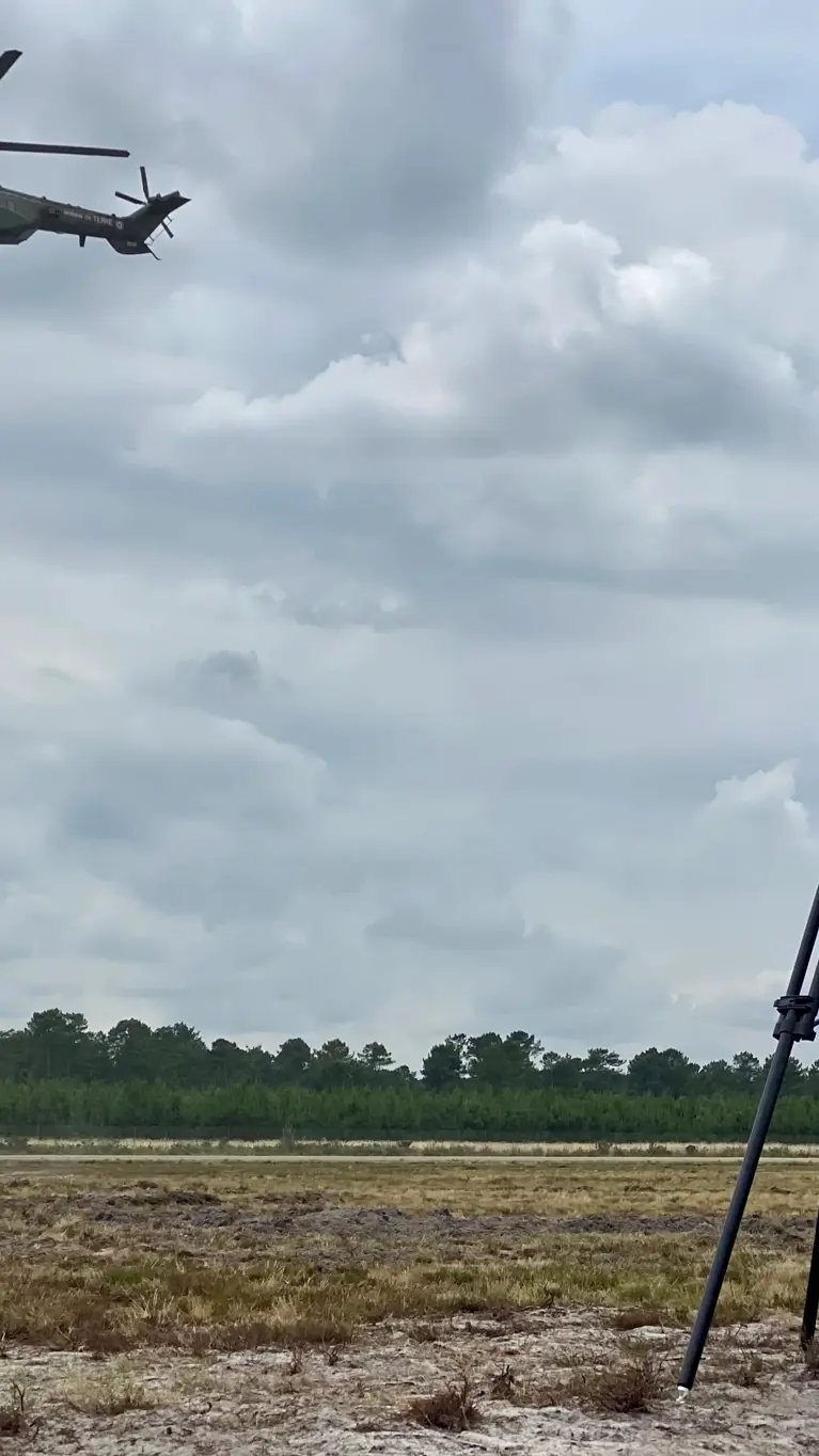 Op de voorgrond een radar, op de achtergrond militairen die met een touw afdalen uit een helikopter. 