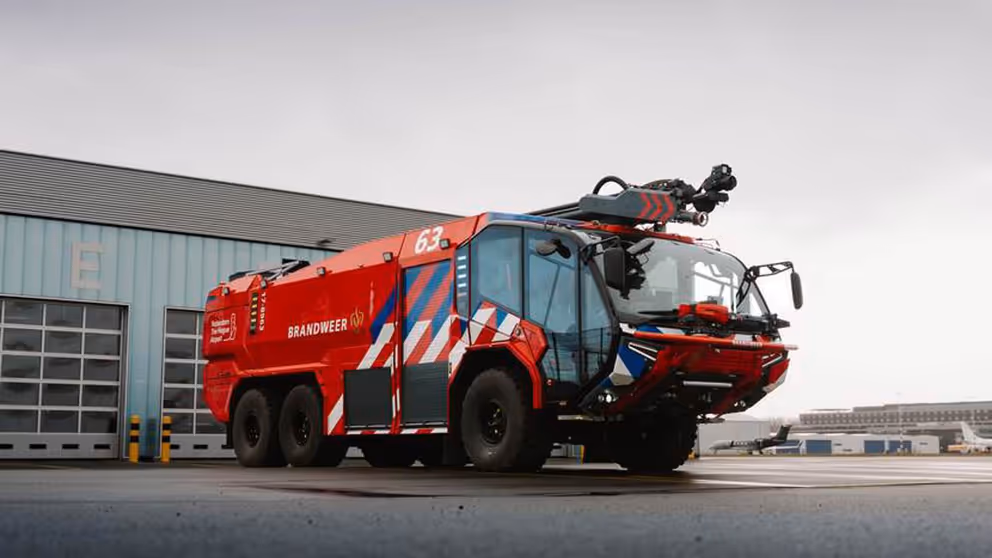 Brandweervoertuig met veel rood, blauwwitte strepen en grote glazen cabine.