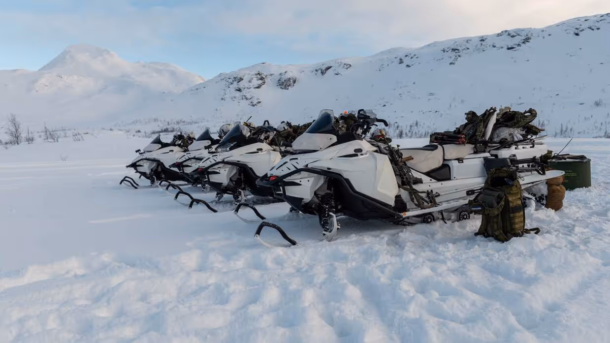 Sneeuwscooters in besneeuwd landschap.
