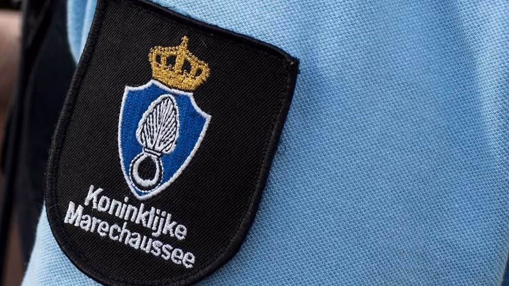 Logo van de marechaussee op de arm van een militair in uniform. 