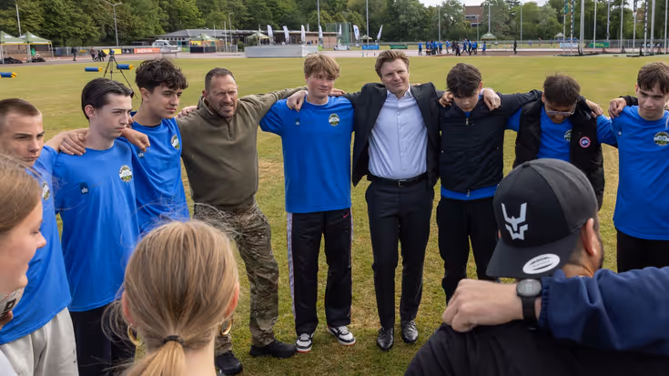 Mensen in een kring, onder wie de minister.