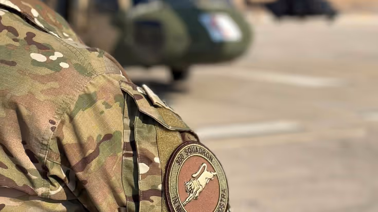 Schouder van militair in uniform in beeld met daarop logo luchtmacht squadron.