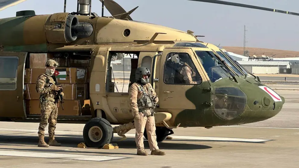 Helikopter staat aan de grond met 2 militairen erbij.