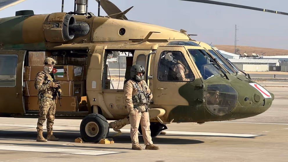 Helikopter staat aan de grond met 2 militairen erbij.