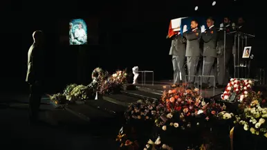  Mix van beelden van Mark. Zo zien we dat zijn kist wordt gedragen door militairen en dat zijn baret en onderscheidingen plechtig worden gedragen door een collega.