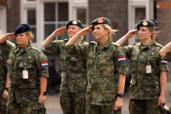 Militairen salueren, onder hen de koningin.