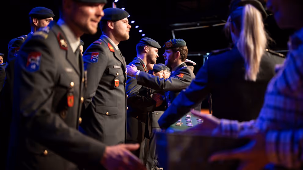 Militairen staan in tenue in rij te wachten op hun medaille