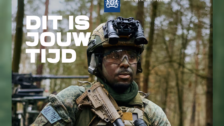 Een man in militaire kleding kijkt langs de camera.
