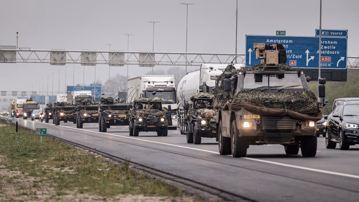 Militaire colonne rijdt over Nederlandse snelweg A1 ter hoogte van afslag Voorst.