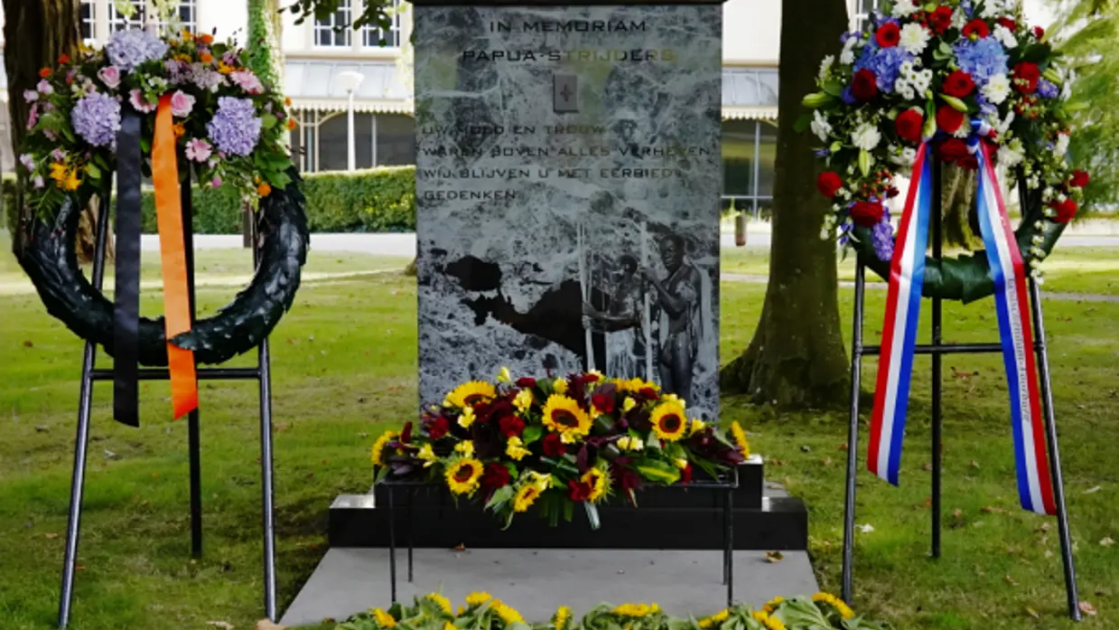 Het monument met een krans ervoor. 