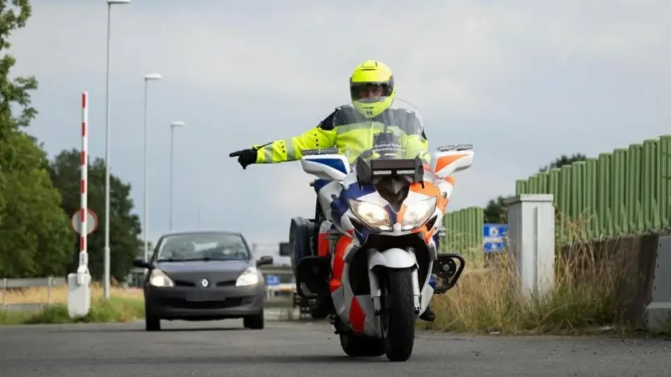 Motorrijder wijst een auto naar de zijkant van de weg