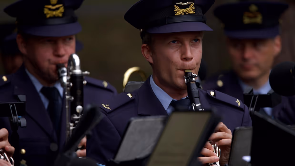 3 militairen met muziekinstrumenten.