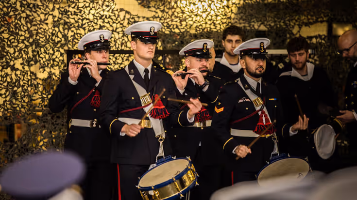 Tamboers en pijpers maken muziek.
