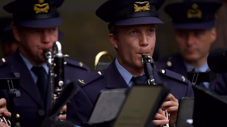 3 militairen met muziekinstrumenten.