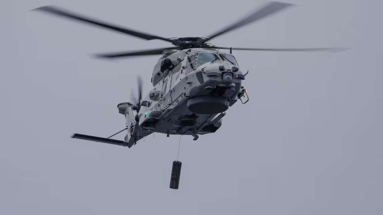 Een NH90-helikopter met daaronder de Long-Range Active Sonar.